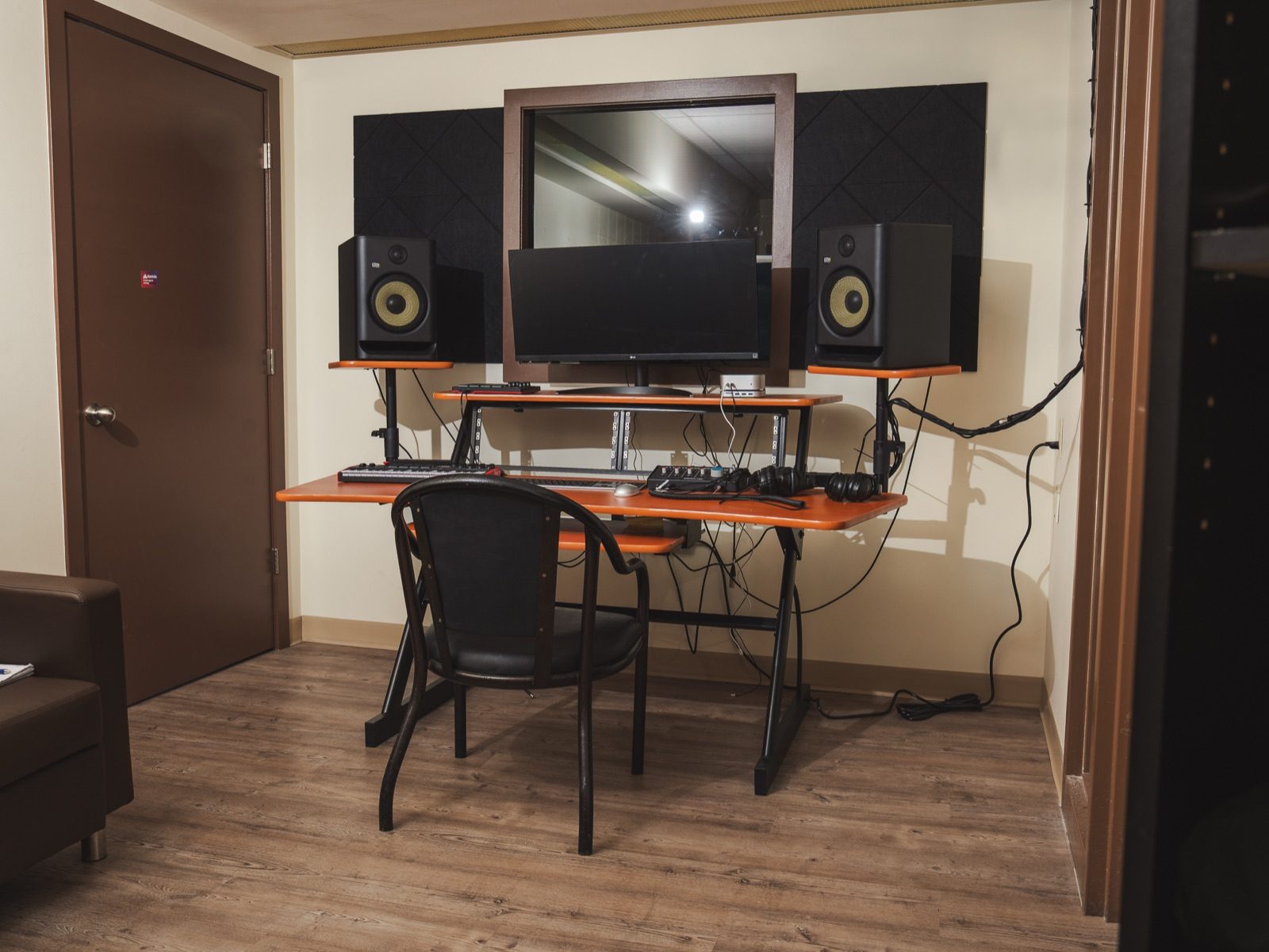 Music production room with studio monitors, mixing desk, and acoustic panels